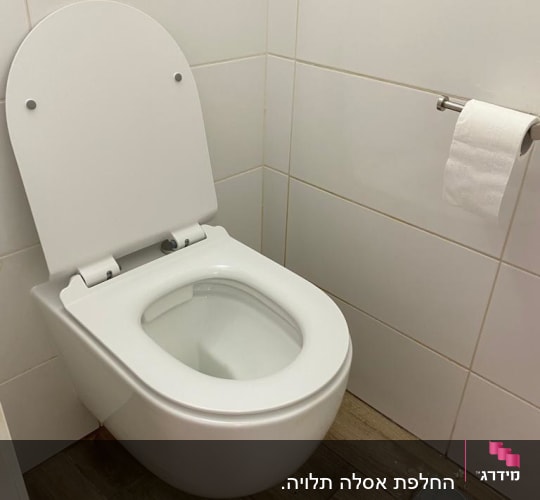 אסלה תלויה על קיר עם נייר טואלט